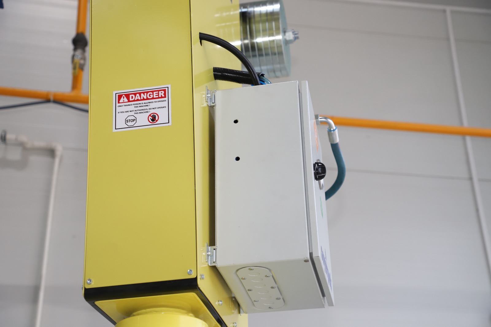 A Soyerpek industrial manipulator arm handling a precision part in a factory setting.