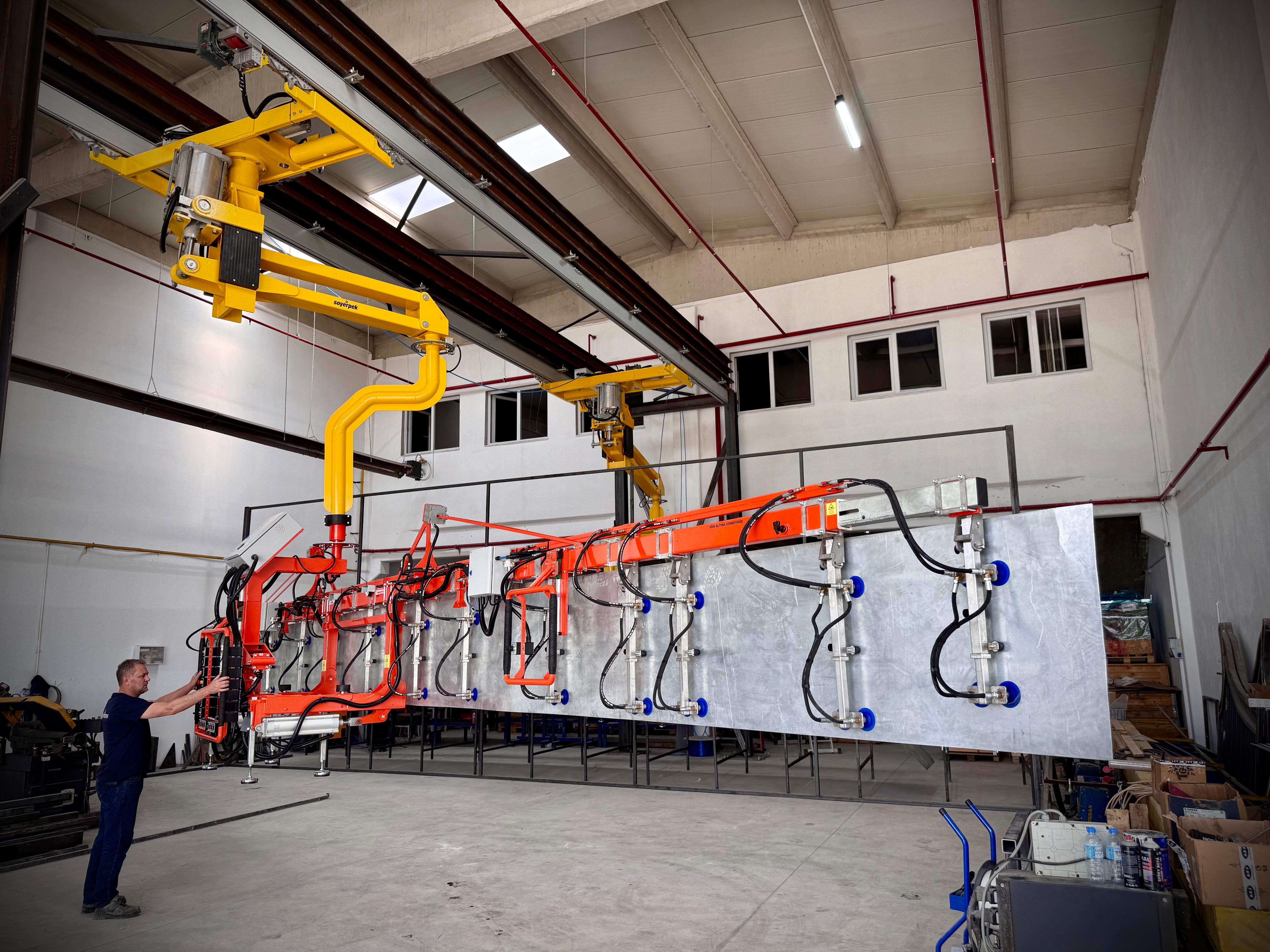 A technician positioning a Soyerpek industrial manipulator arm for a precise task.