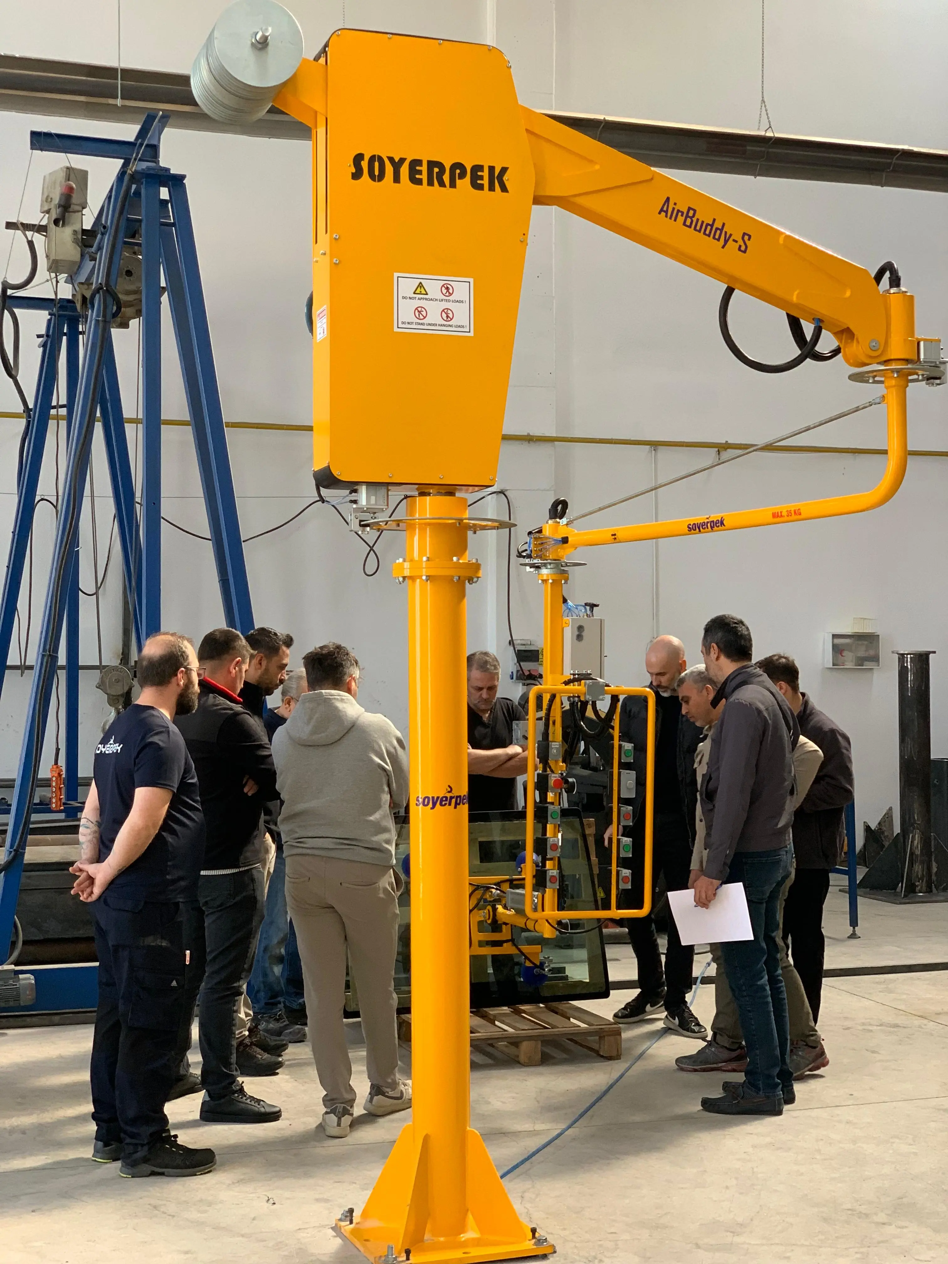 Manipulateur industriel de transport de verre Soyerpek dans une ligne de production de tracteurs effectuant une opération d'assemblage de verre sous vide. Système de manipulateur de verre sûr et précis